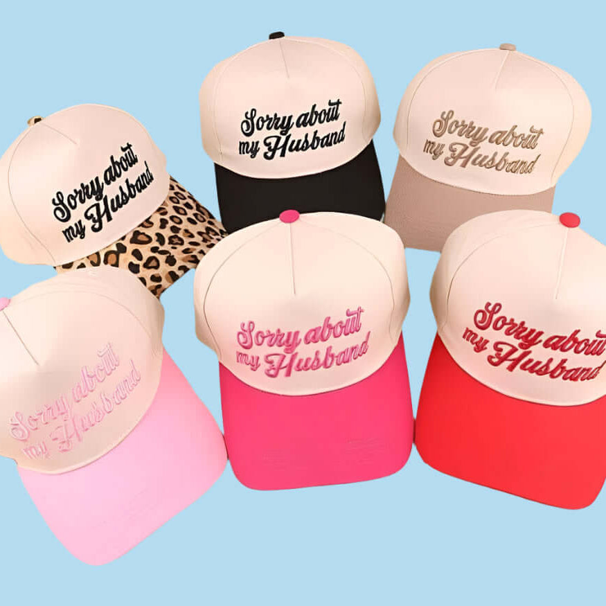 Colorful collection of 'Sorry About My Husband' trucker hats showcasing fun designs and playful embroidery.