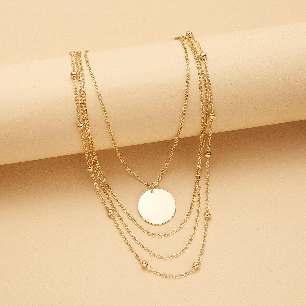 Gold layered necklace set with a sleek round pendant and bead accents, perfect for an elegant look.