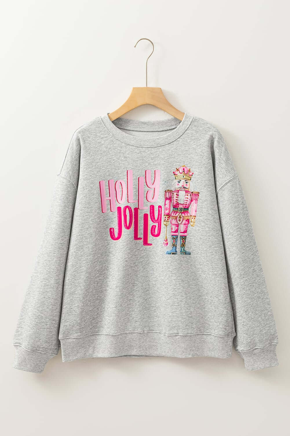 Gray sweatshirt with nutcracker design and 'HOLLY JOLLY' print for festive holiday style.