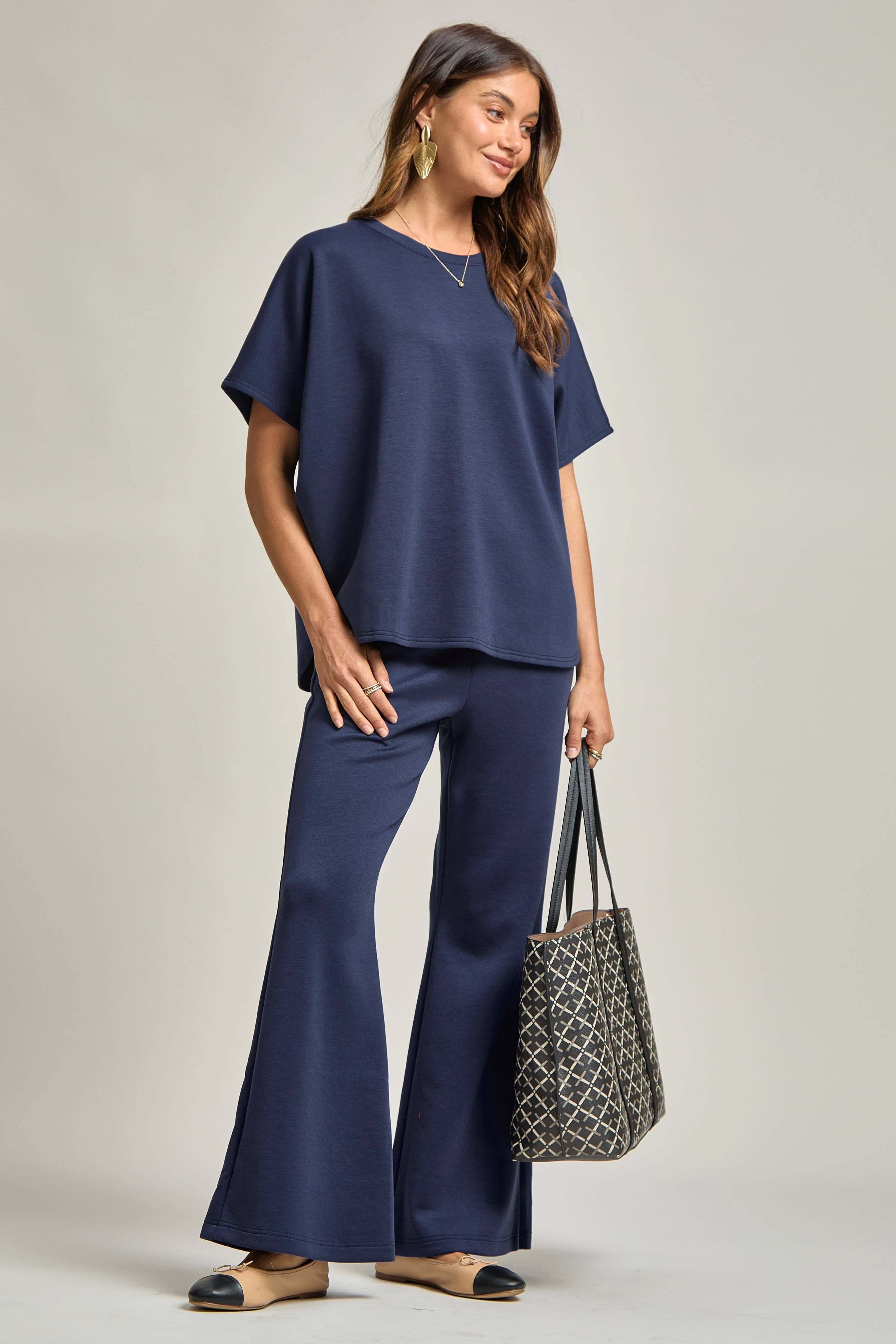 Model wearing a Poncho Top + Bell Bottom Modal Set, complete with a bag and stylish shoes, showcasing comfort and style.