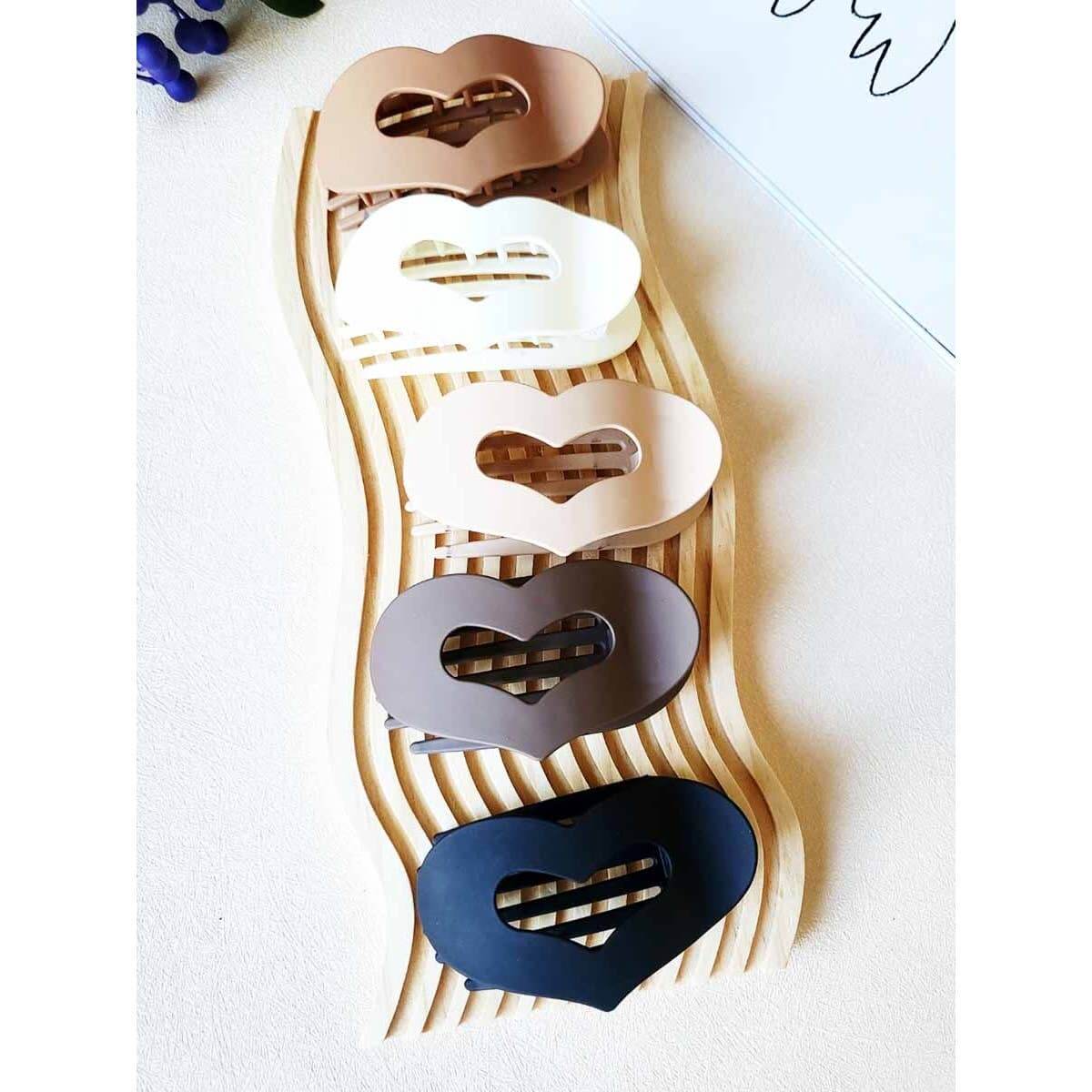 LOVE YOU MORE HAIR CLIPS in five matte neutral shades displayed on a stylish wave rack.