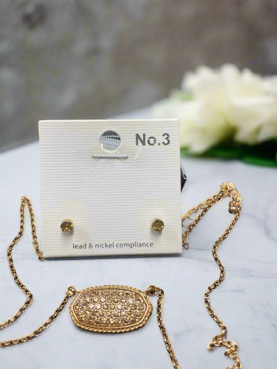 Druzy oval pendant necklace and matching stud earrings on display, showcasing elegant design in gold.