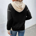 Back view of a woman wearing the MODERN EDGE HOODIE featuring black and beige color block design.