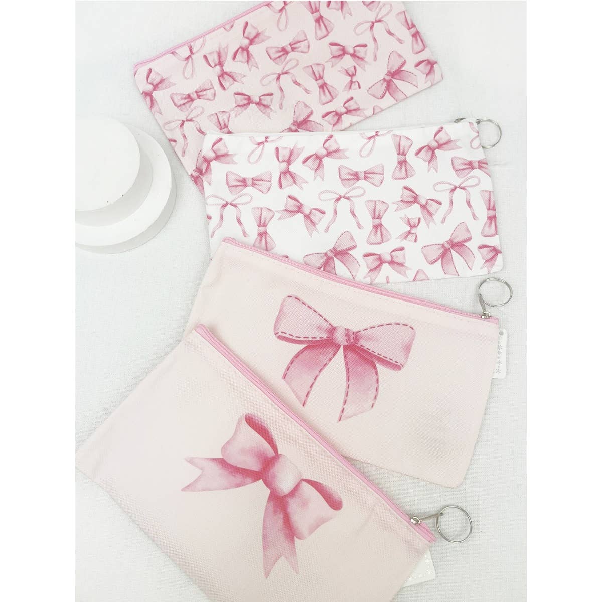 BOW ME OVER COSMETICS BAG set with pink bow designs, perfect for organizing makeup essentials and daily use.