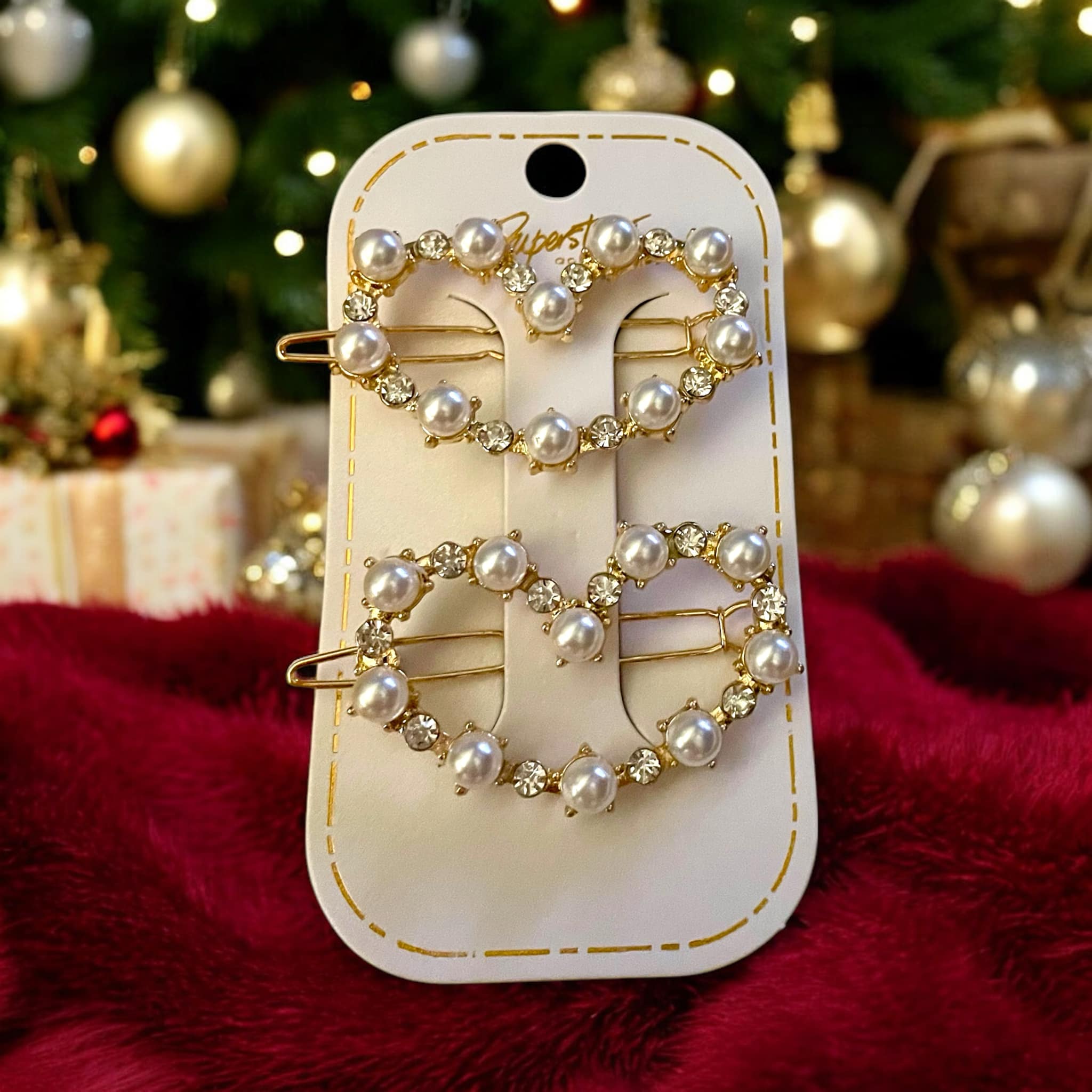 Set of two gold tone barrettes with pearl and rhinestone designs in heart and round shapes.