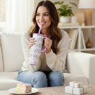 Woman enjoying her MAKE A WISH 30 oz - SWIG mug with confetti design while sitting on a couch.