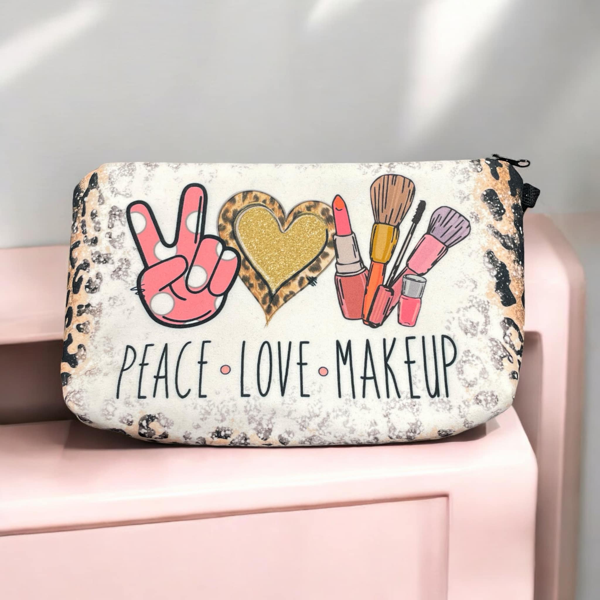 "Peace, Love & Makeup" bag with leopard print, hearts, and makeup brushes; perfect for organizing cosmetics.