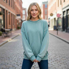 DOWNTOWN DRIFT CREW NECK worn by model in urban setting, showcasing its cozy mineral wash fleece design.