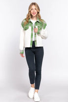 Model showcasing the ALPINE CHARM JACKET in pine green plaid flannel and sherpa, styled for winter fashion.