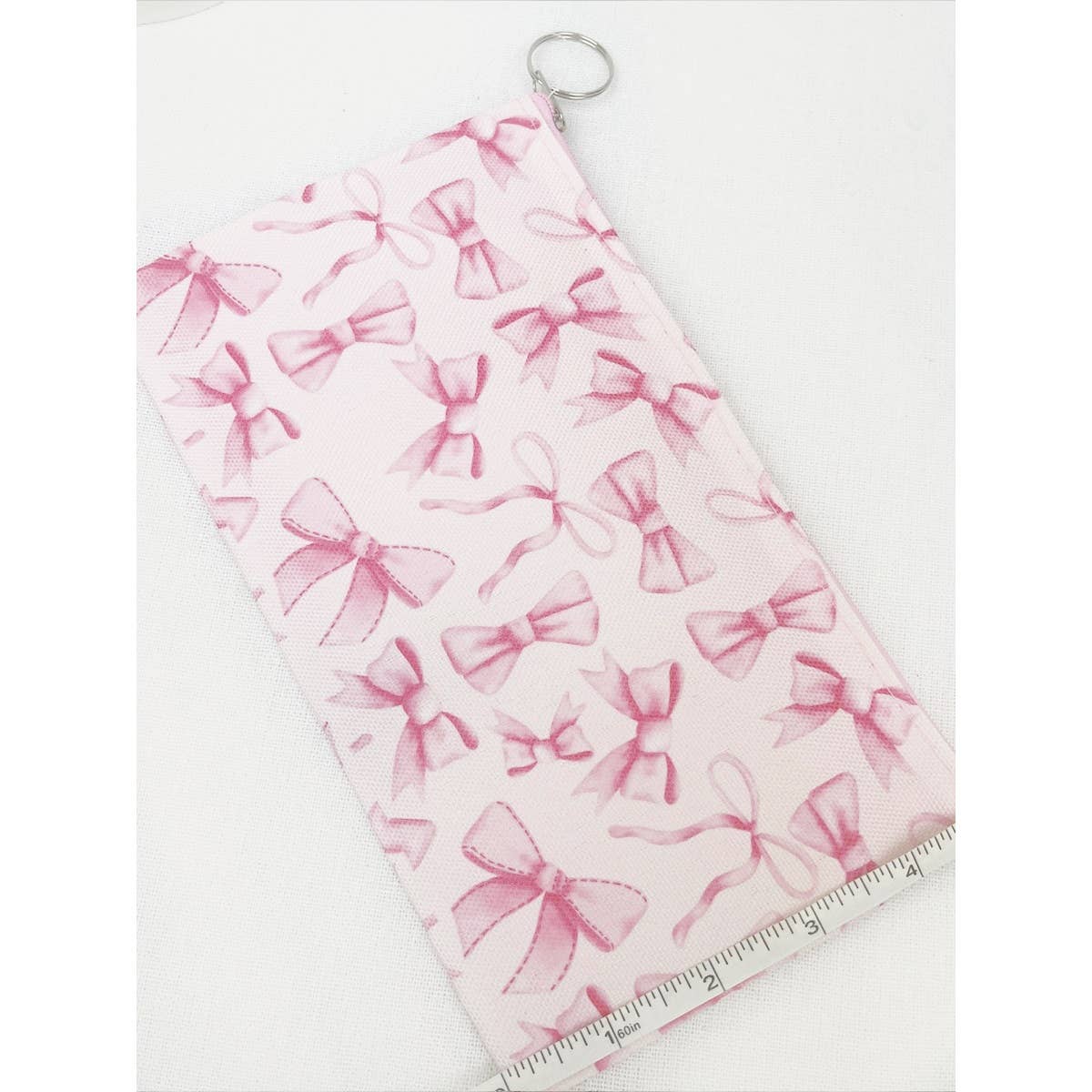 BOW ME OVER COSMETICS BAG in pink with ribbon design, perfect for organizing everyday makeup essentials.