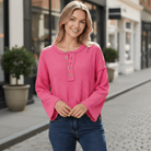 Model wearing CASUAL CHARM TOP - Zenana in pink, showcasing relaxed henley style and flowy sleeves in a stylish outdoor setting.