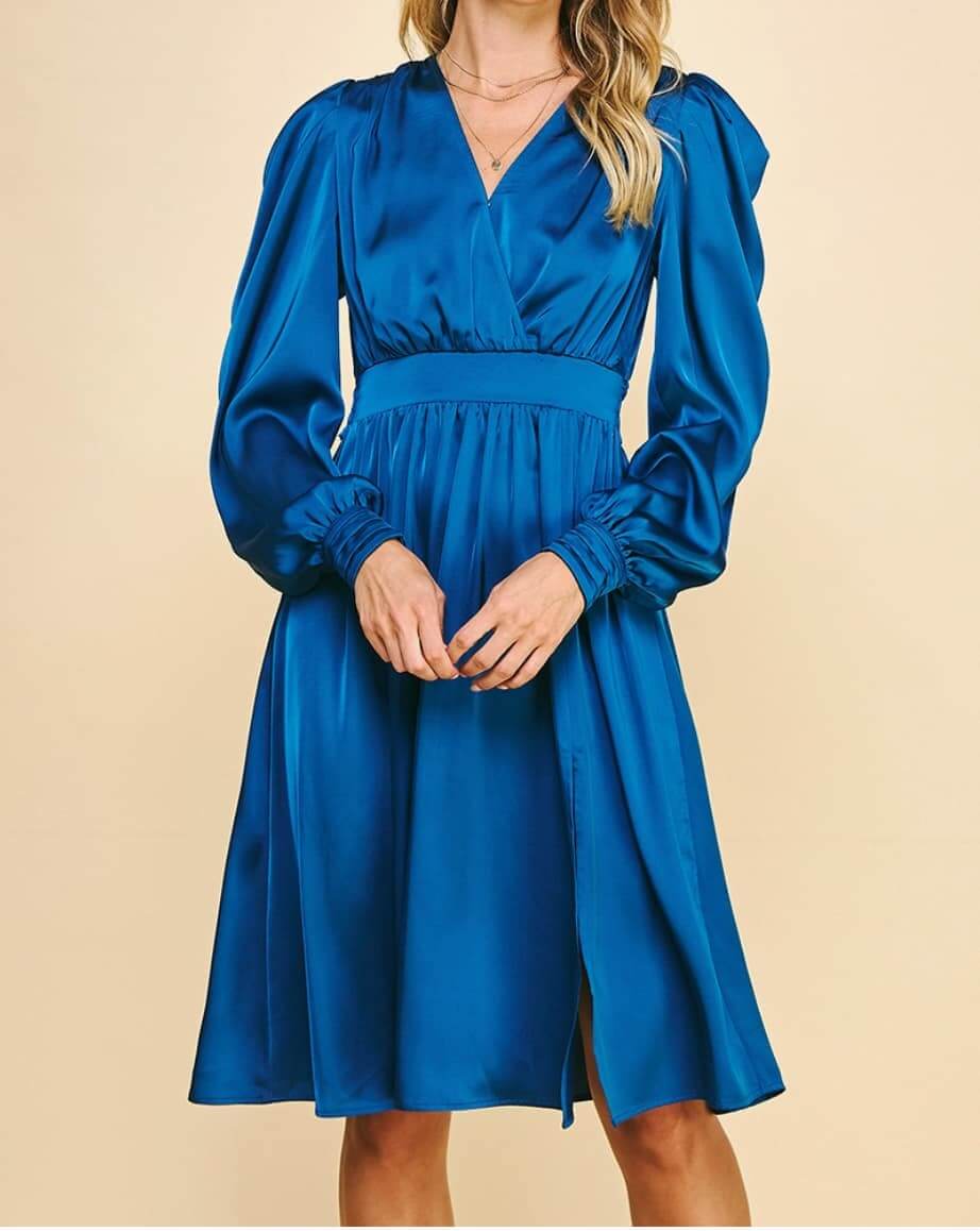 Indigo Hour Midi Dress by Pinch, featuring a surplice bodice, puff sleeves, and a front skirt slit in silky blue fabric.