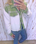 Woman wearing ALPINE CHARM JACKET in green plaid flannel and sherpa, showcasing a cozy, relaxed fit.