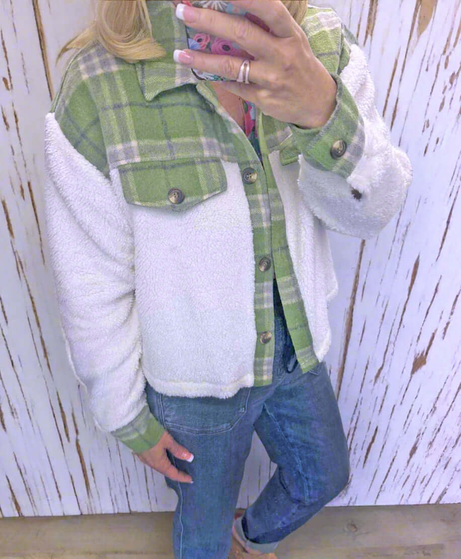 Woman wearing ALPINE CHARM JACKET in green plaid flannel and sherpa, showcasing a cozy, relaxed fit.