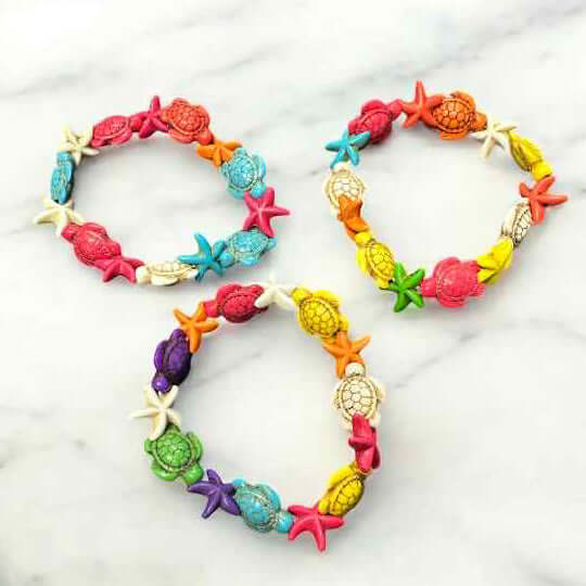 Vibrant Tidepool Treasures Bracelet featuring colorful turtle, shell, and starfish beads on a marble surface.