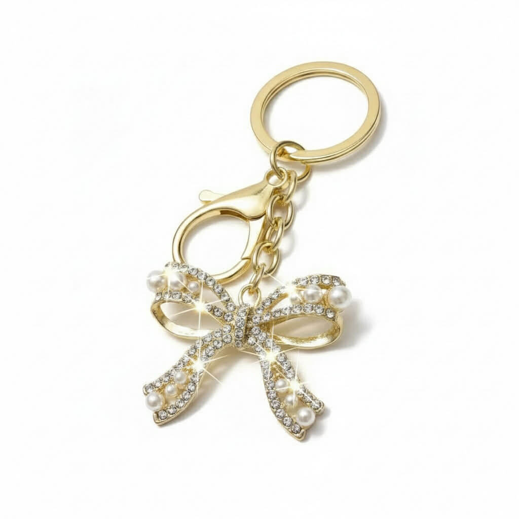 ENCHANTED BOW Bag Charm / Keychain with shimmering rhinestones and faux pearls in gold tone.