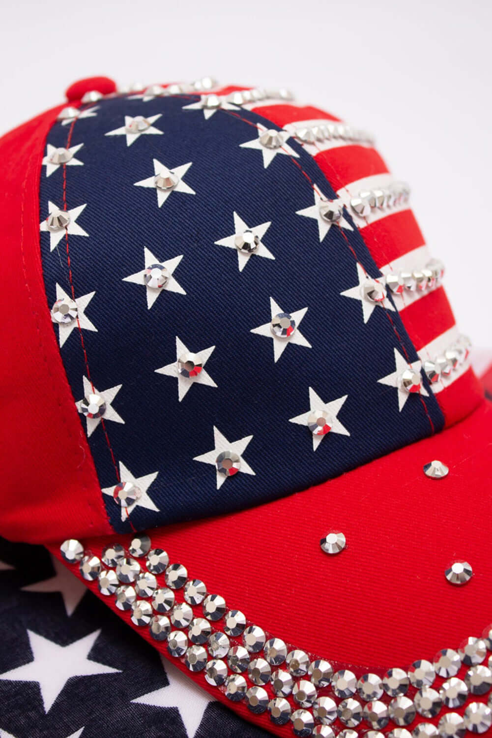 Red baseball cap featuring American flag design and rhinestone embellishments for a stylish, patriotic look.