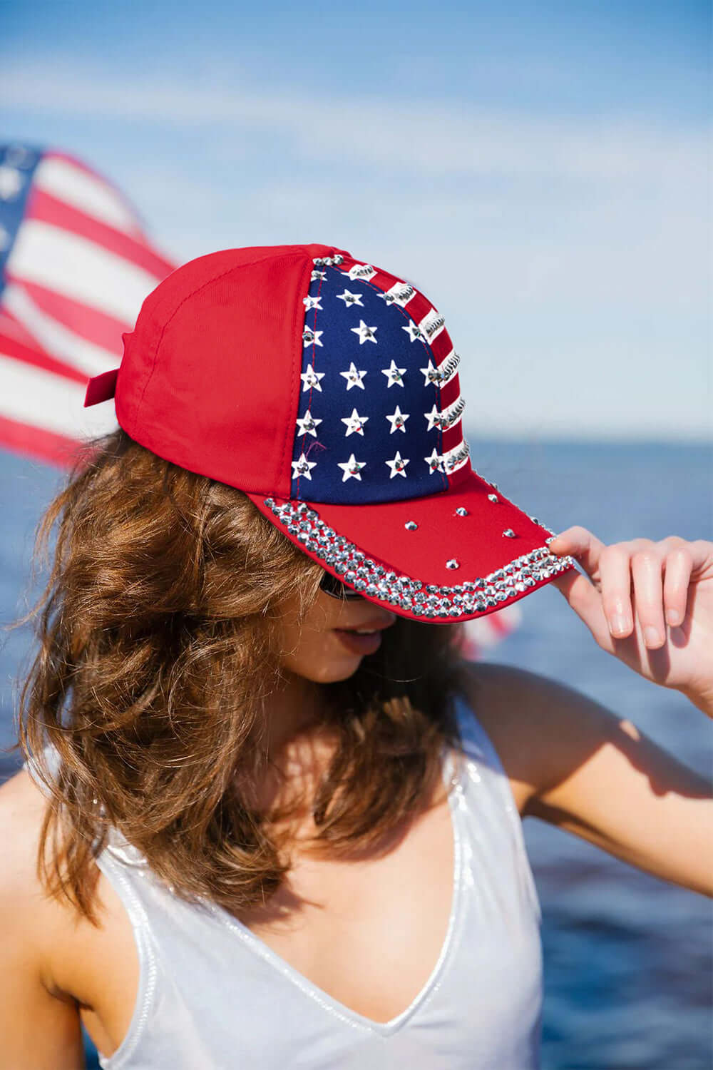 Let Freedom Bling cap featuring American flag design, rhinestones, and a fiery red base for patriotic style.