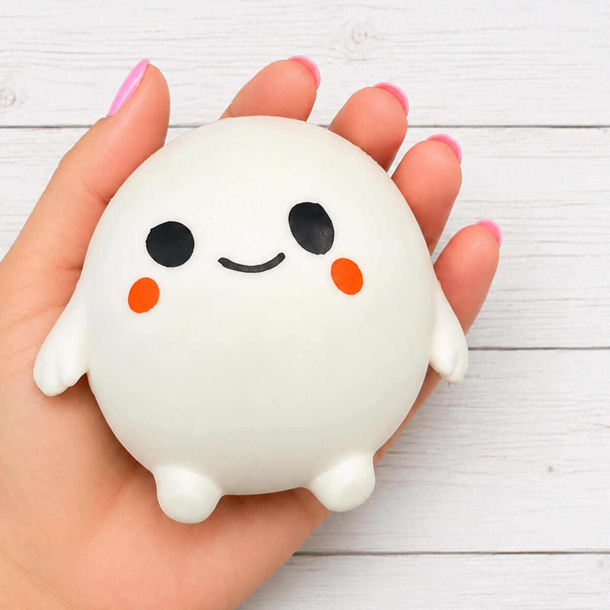 A hand holding the BOO GHOST DUMPLING squishy toy featuring a cute ghost design with rosy cheeks.