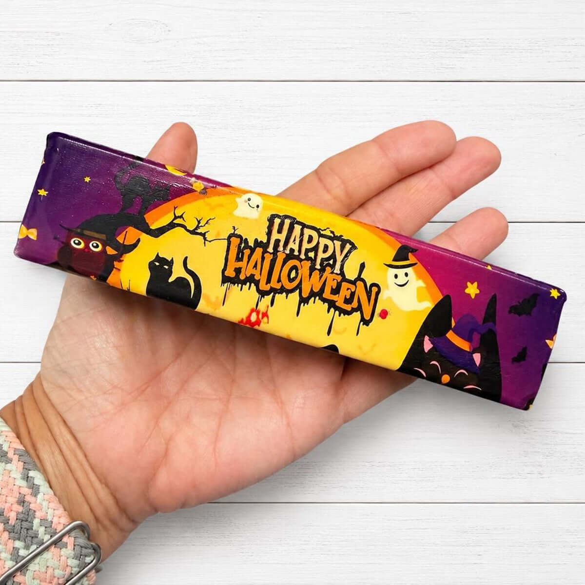 HALLOWEEN BUTTER SQUISHY with a colorful spooky design featuring ghosts, bats, cats, and Halloween text.