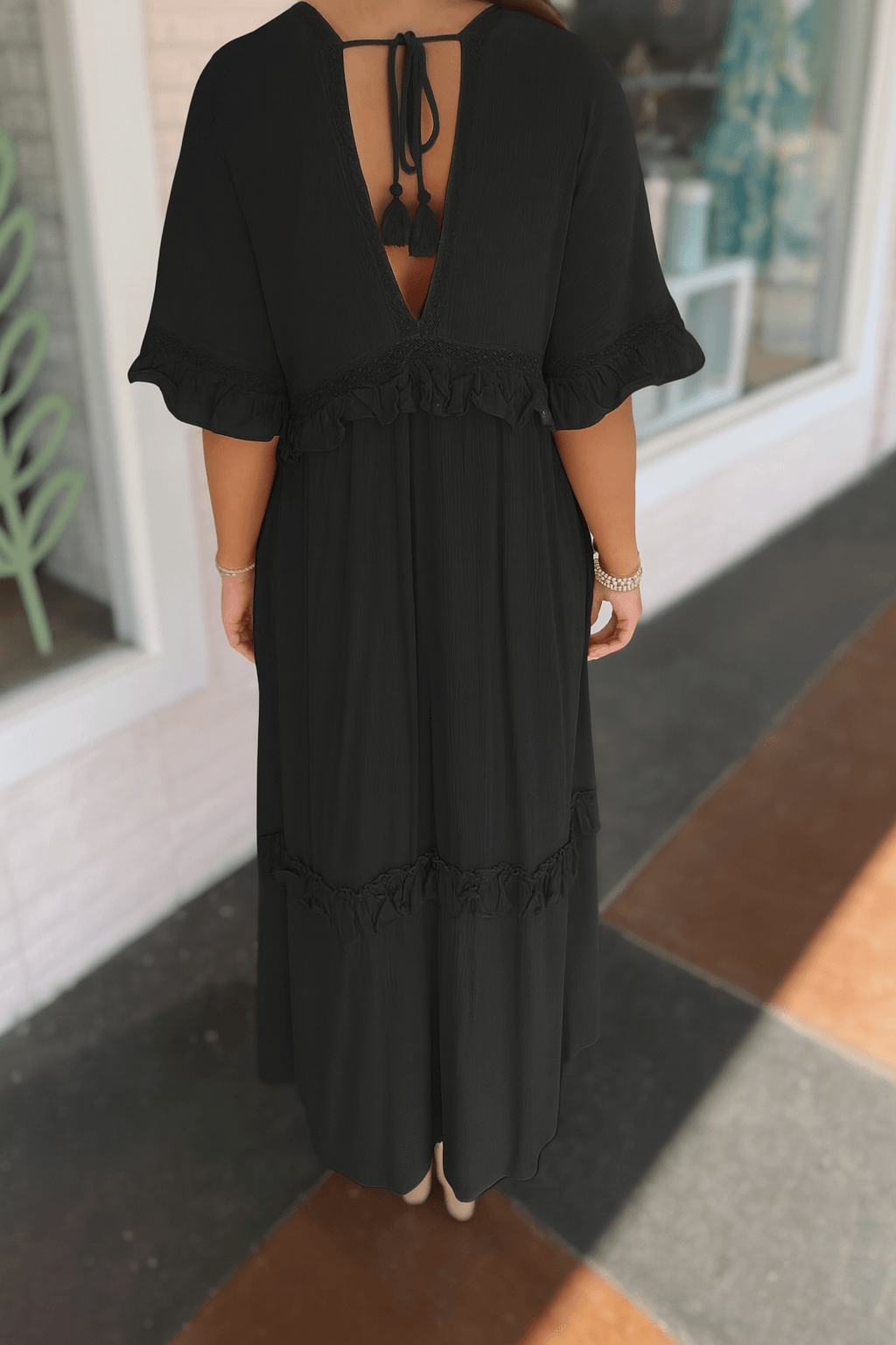 Back view of a black Ever After maxi dress with ruffles and tie-back detail, perfect for romantic occasions.