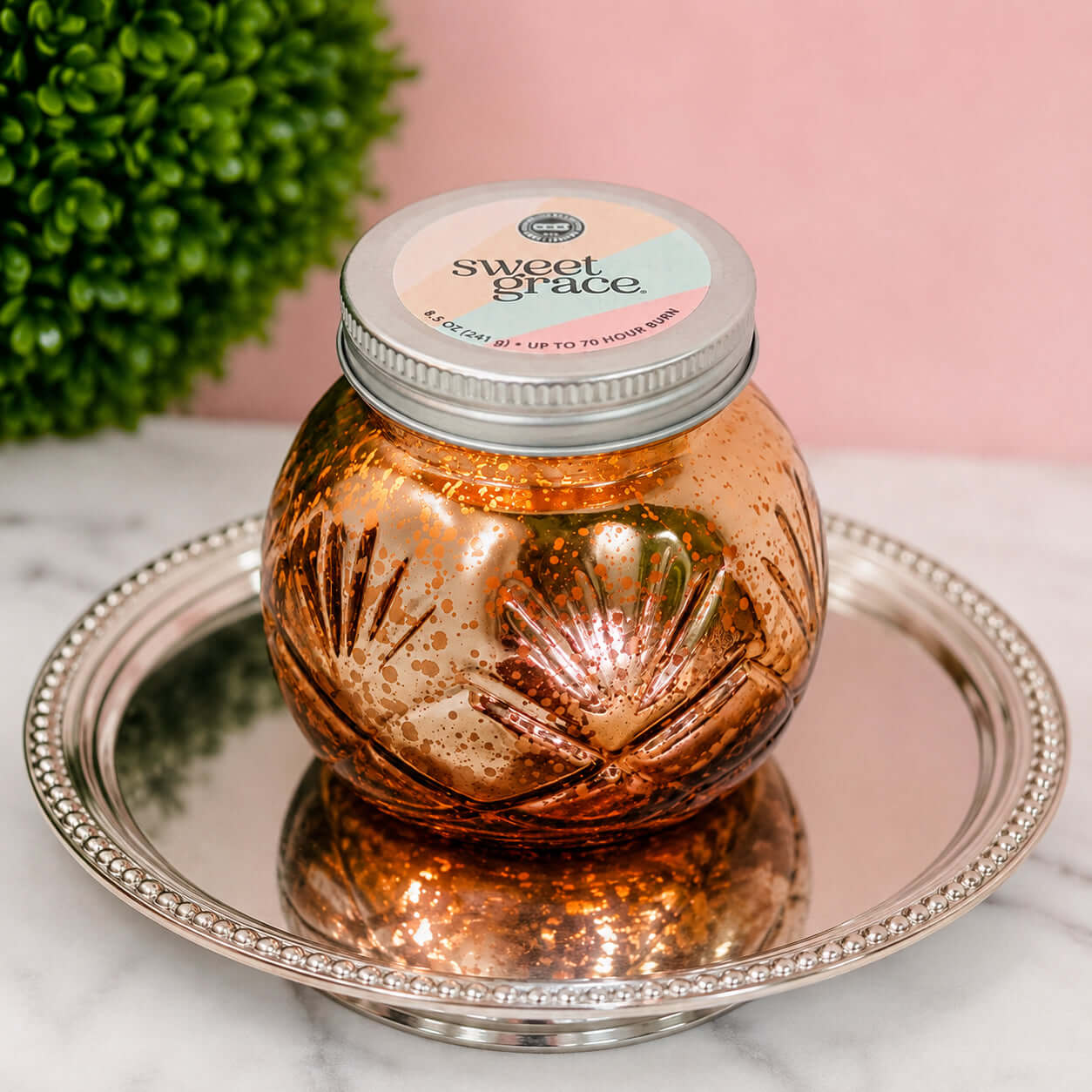 SWEET GRACE CANDLE - ANTIQUE GOLD displayed on a metallic tray, showcasing its elegant design and beautiful fragrance.