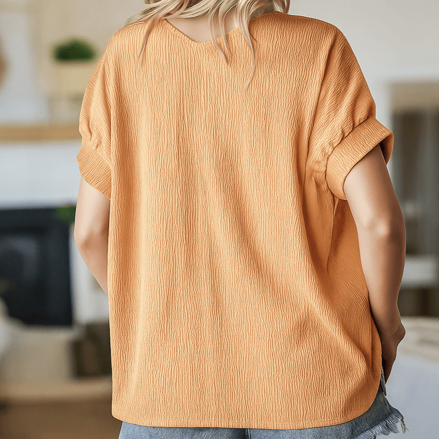 Back view of a relaxed-fit apricot textured top with short sleeves and V neckline, perfect for casual styling.