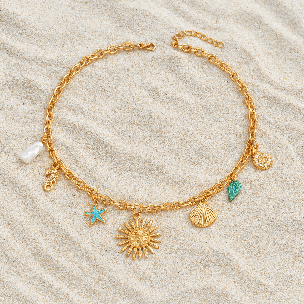 Sunseeker Charm Necklace with golden sun, teal starfish, seashells, and pearl accents on sand backdrop.