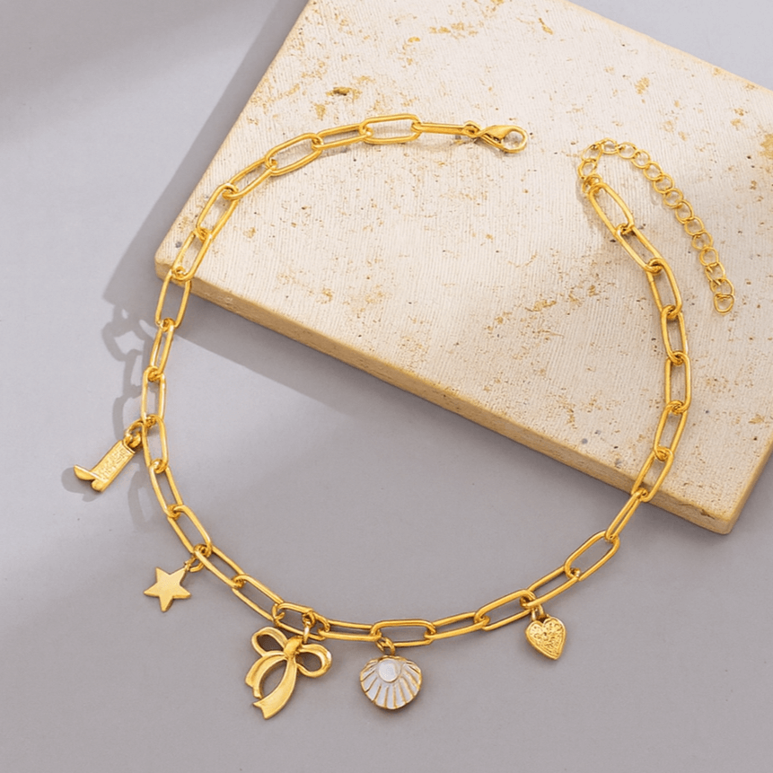 Gold-tone Coastal Darling Charm Necklace with seashell, heart, star, and boot charms on a paperclip chain.
