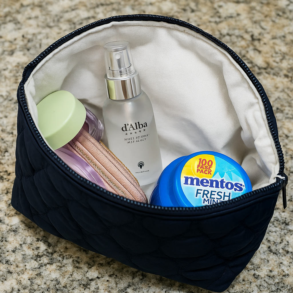 Heart-embossed navy quilted makeup bag filled with skincare and mint products.