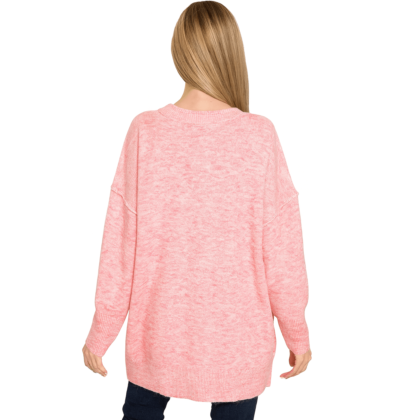 Back view of a woman wearing the SWEET HAVEN TOP, a soft pink oversized sweater with a hi-low hem.