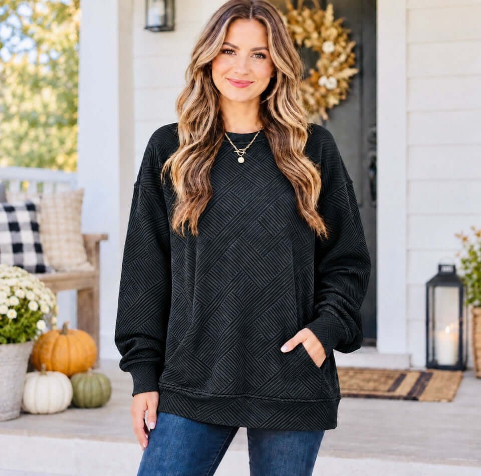 Model wearing a WARM WISHES PULLOVER (black) with a textured pattern, showcasing its cozy comfort and relaxed style.