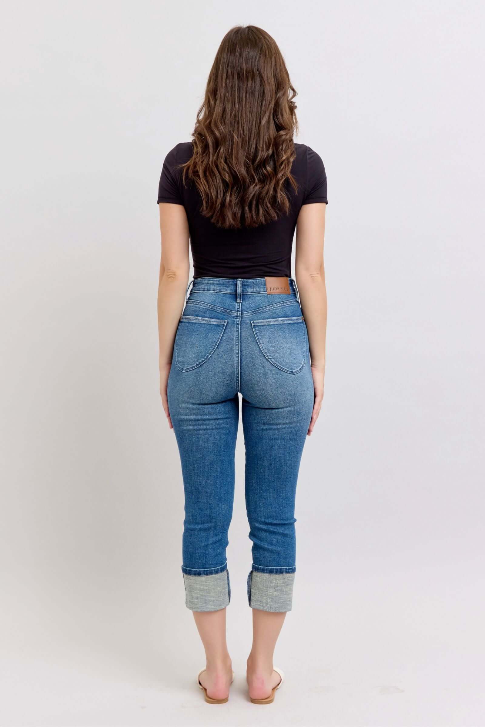 Model wearing JUDY BLUE Charli Capris, medium wash, high waist, cuffed style from the back, showcasing no distressing.