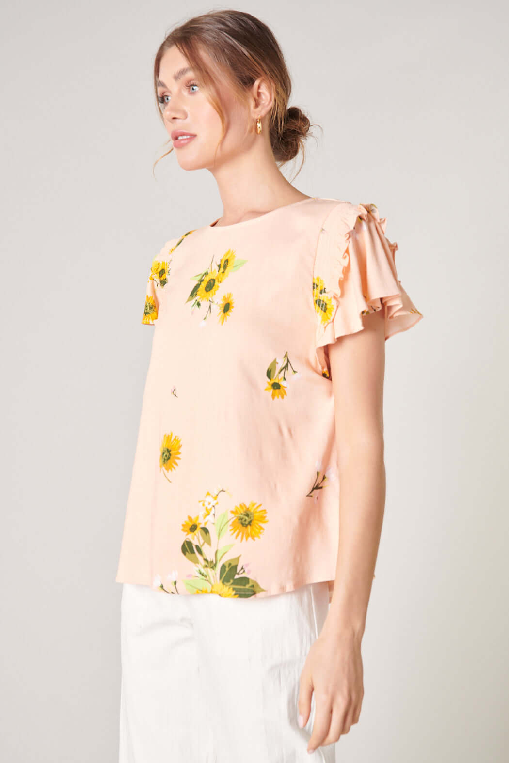 Daisy Marie Top from SugarLips, featuring sunflower print and smocked ruffle detail in blush yellow.