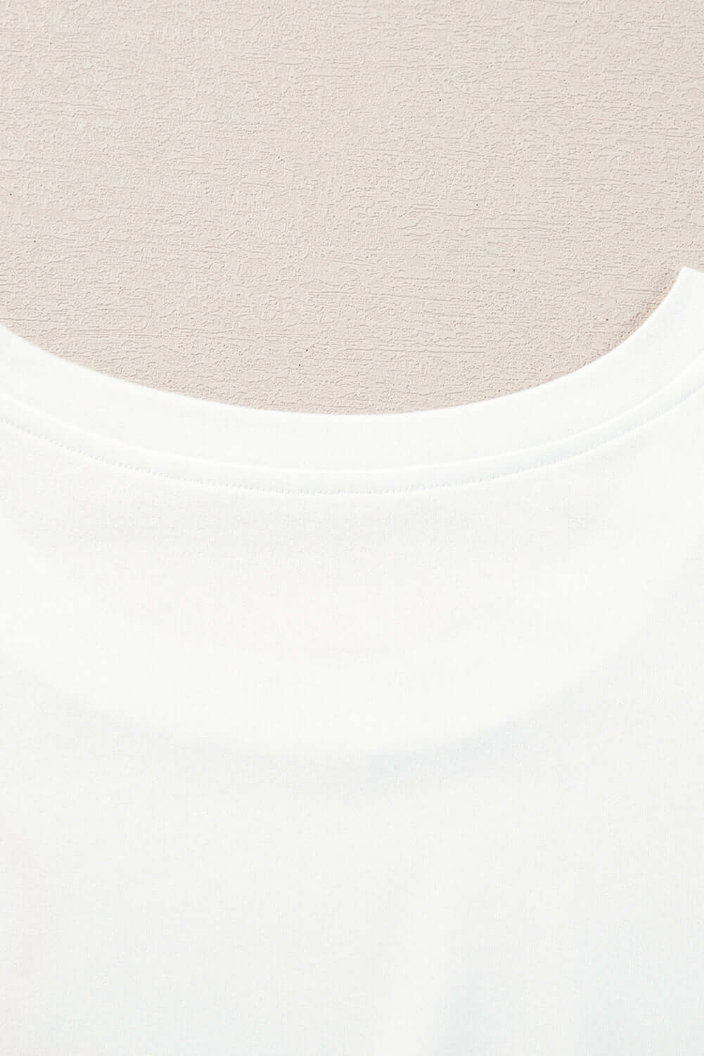 Close-up of a white ruffled tank top neckline designed for a feminine and relaxed fit.