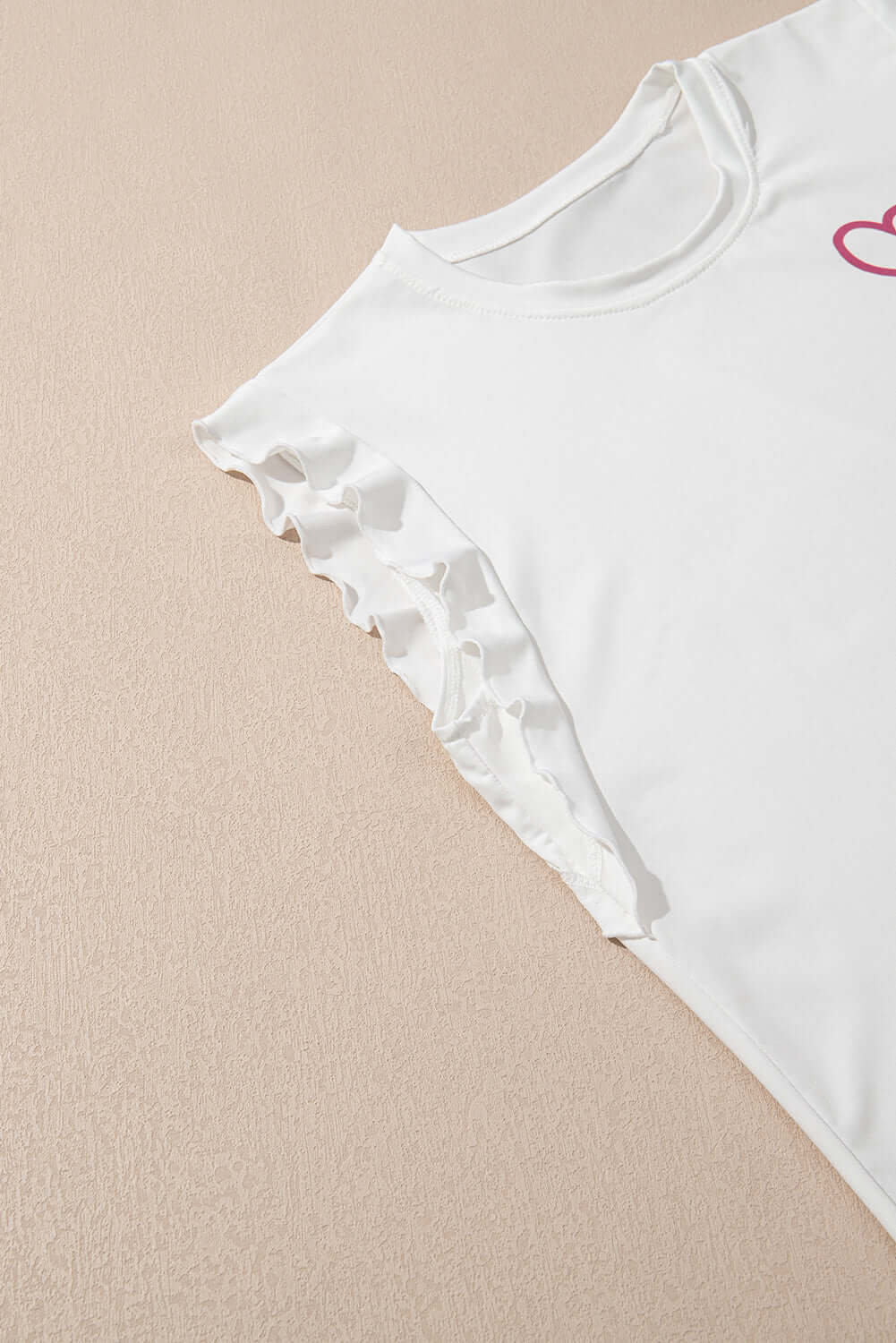 Ruffled white tank top from the Love Language Lounge Set, showcasing feminine details and a heart design.