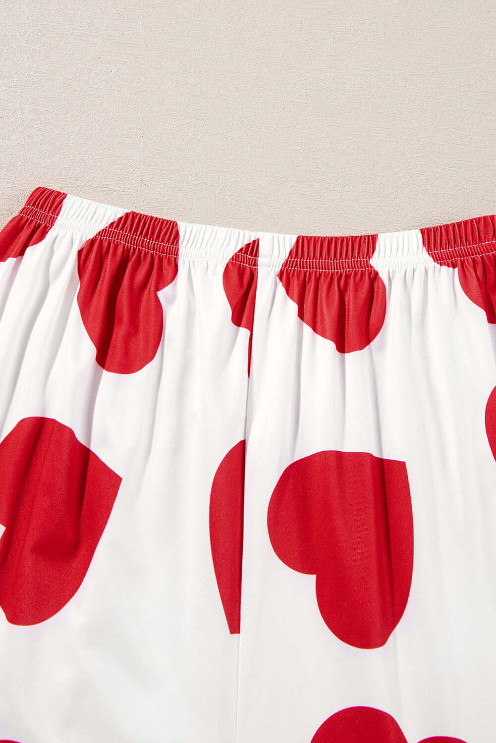 Red heart-print lounge pants with an elastic waistband, perfect for a cozy and playful outfit.