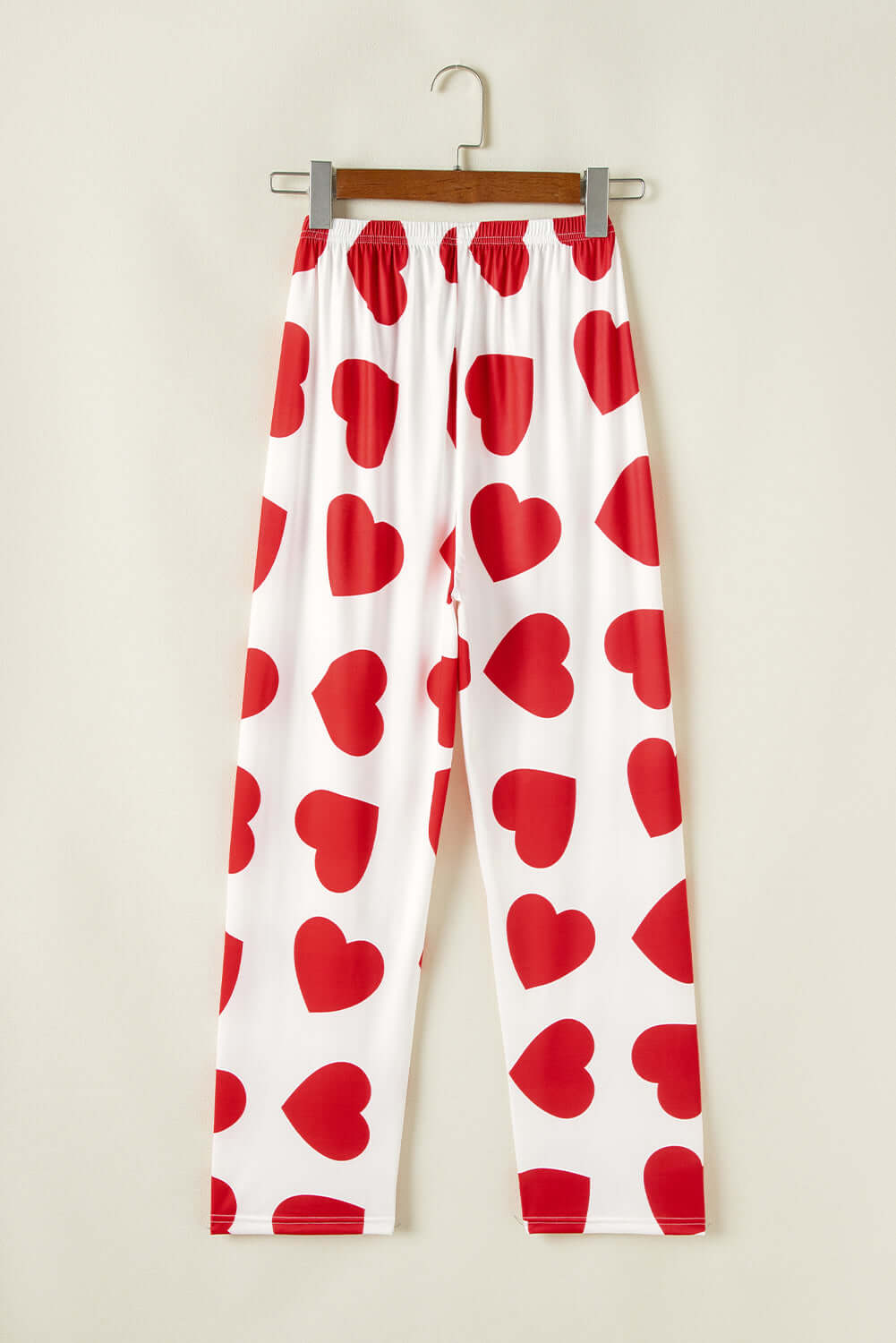 Red heart-print lounge pants on hanger, perfect for cozy and romantic casual wear.