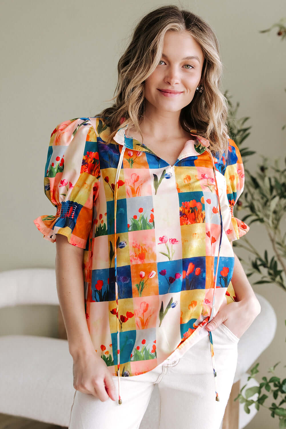 Model wearing the vibrant Garden Window Top blouse with a floral checker print, showcasing playful style and charm.
