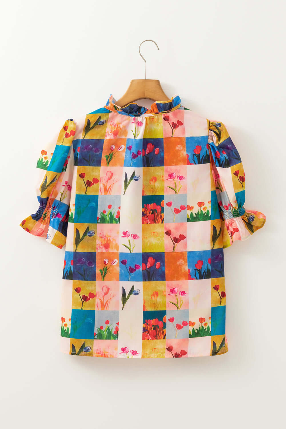 Colorful floral checker print blouse with ruffled sleeves, perfect for brightening any outfit.