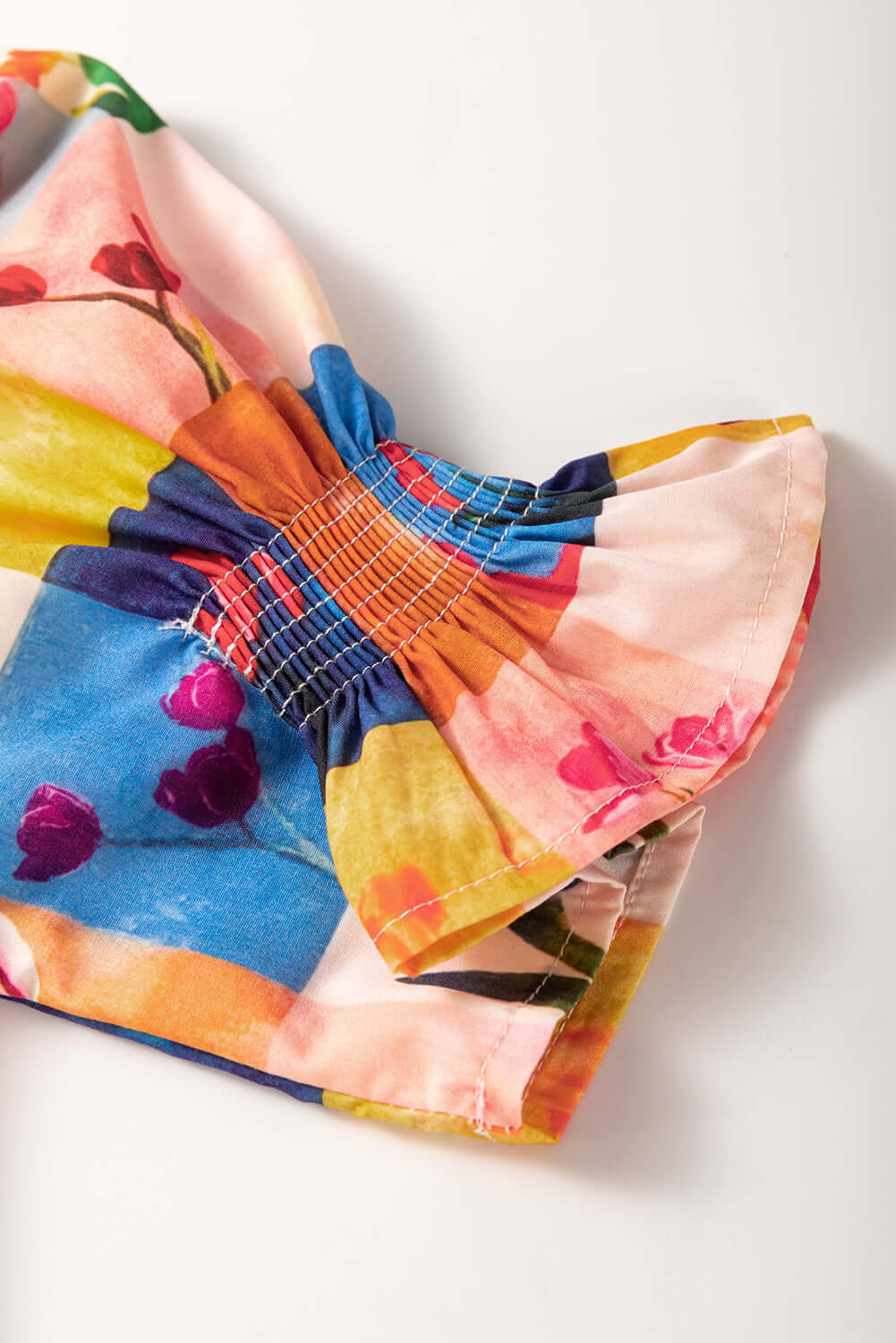 Colorful floral checker print blouse detail showcasing gathering and vibrant design for stylish wear.