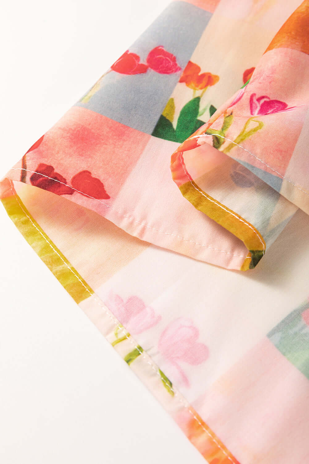 Close-up of floral checker print fabric featuring vibrant colors and patterns, perfect for a stylish blouse.