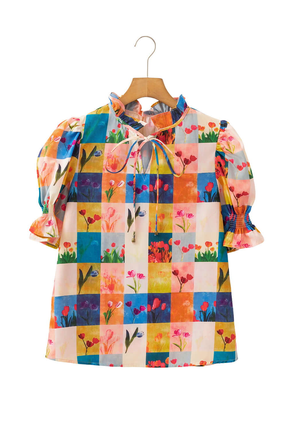 Multicolor floral checker print blouse with puff sleeves on a hanger, evoking a vibrant garden style.