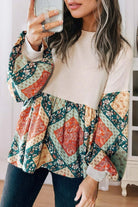 Woman wearing PATCHWORK POETRY TOP with bubble sleeves and geometric patchwork design in warm hues.