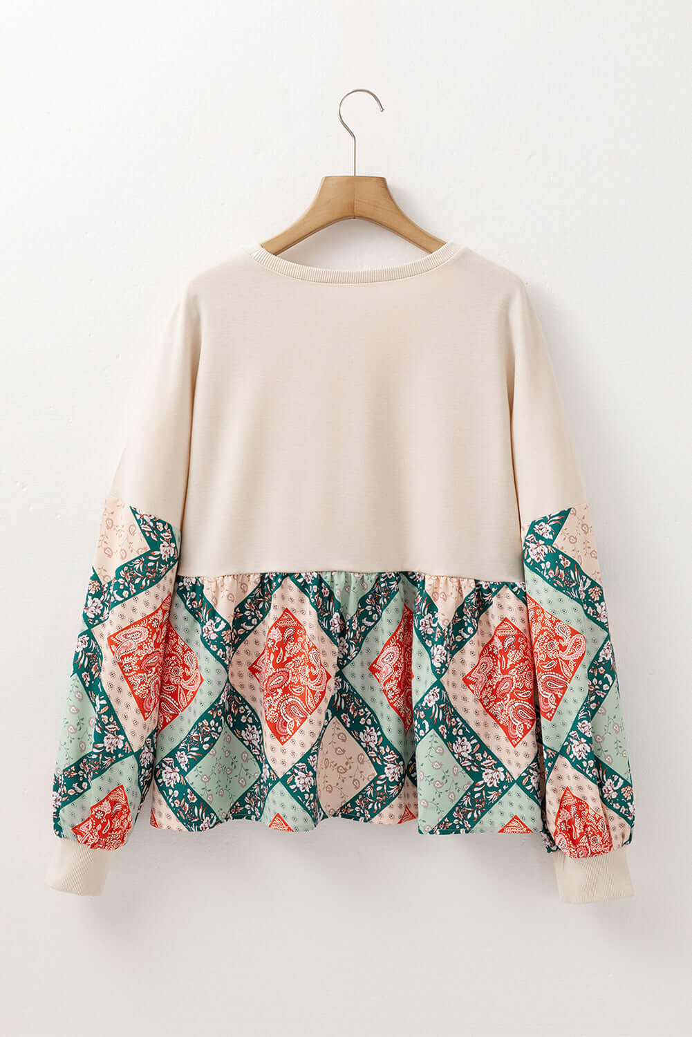Back view of PATCHWORK POETRY TOP showcasing geometric patchwork design in warm colors and bubble sleeves.