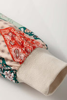 Close-up of the PATCHWORK POETRY TOP showing colorful patchwork sleeve design with textured cuff.