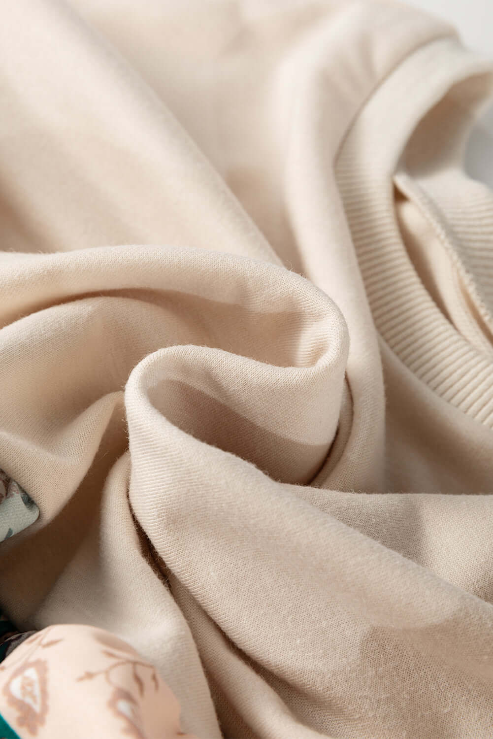 Close-up of the soft fabric of the PATCHWORK POETRY TOP showcasing its cozy texture and warm hues.