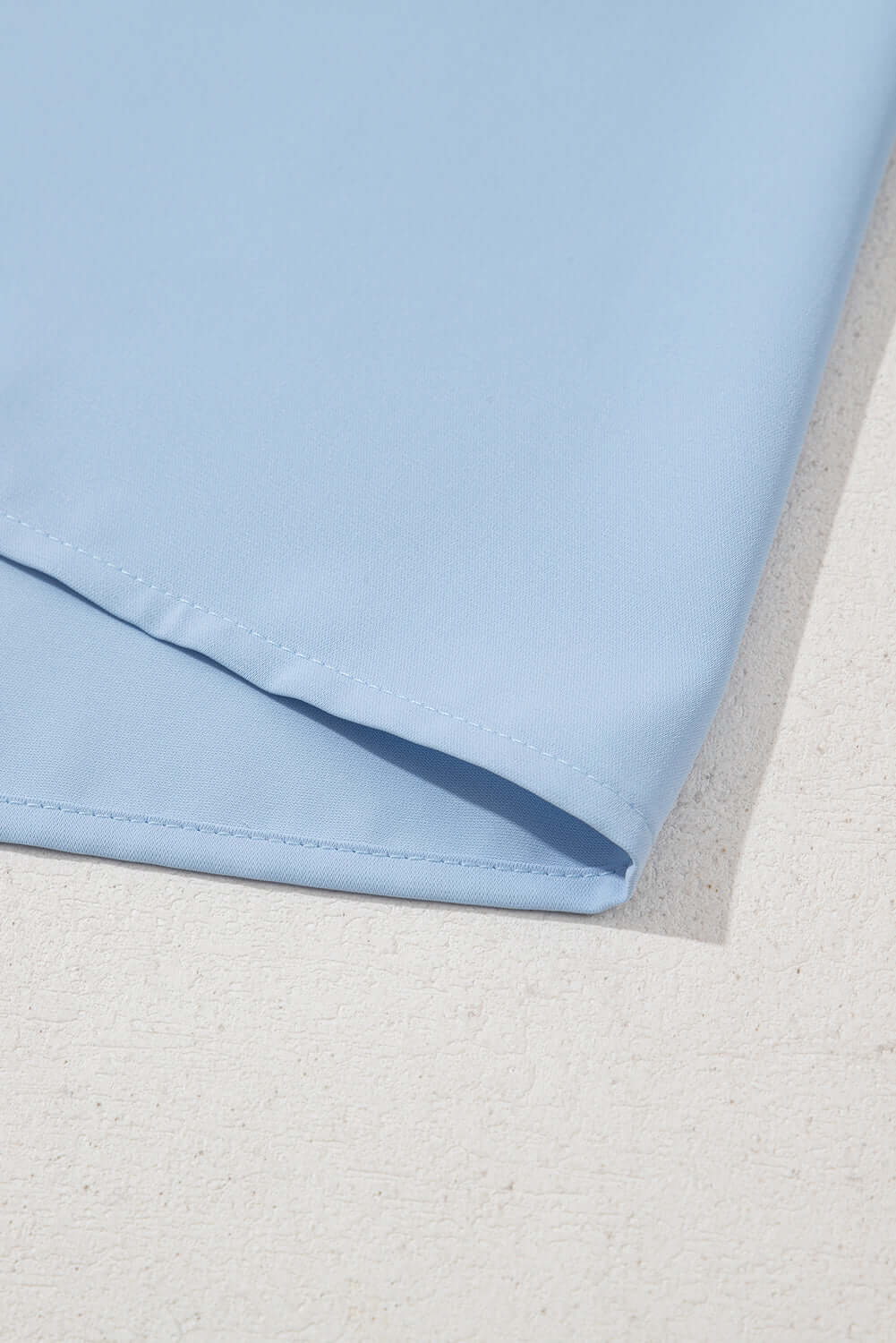 Close-up of the light blue Frill Seeker Top showcasing soft polyester fabric and smooth finish.