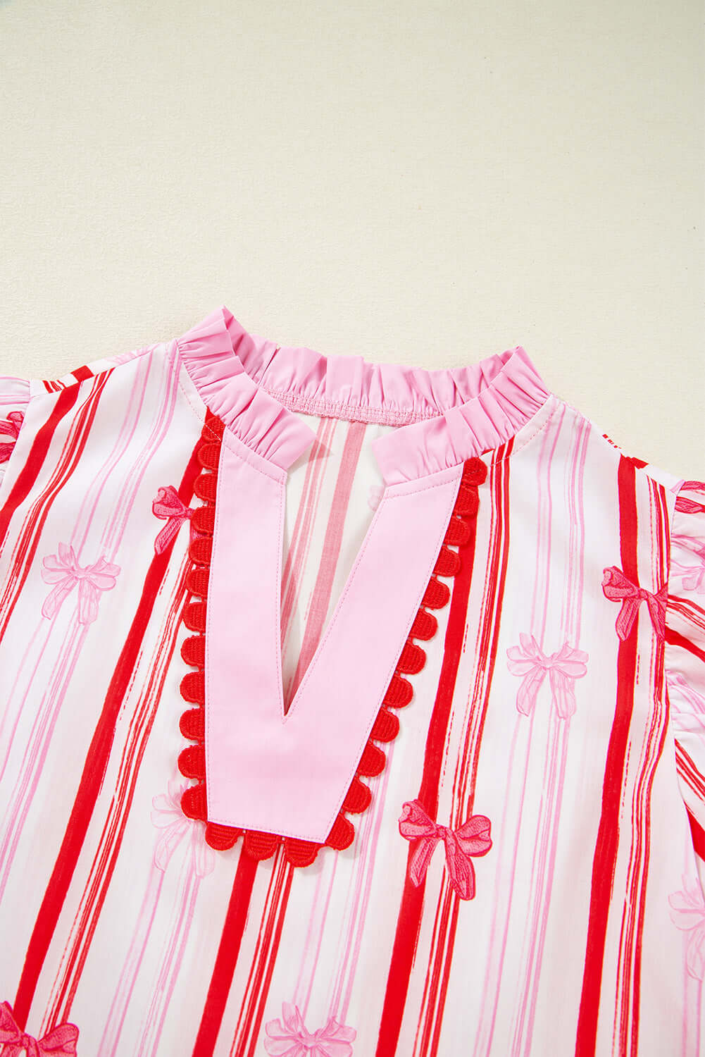 Close-up of the Ribbon Reign Top featuring striped bow print and ric-rac trim, perfect for warm weather fashion.