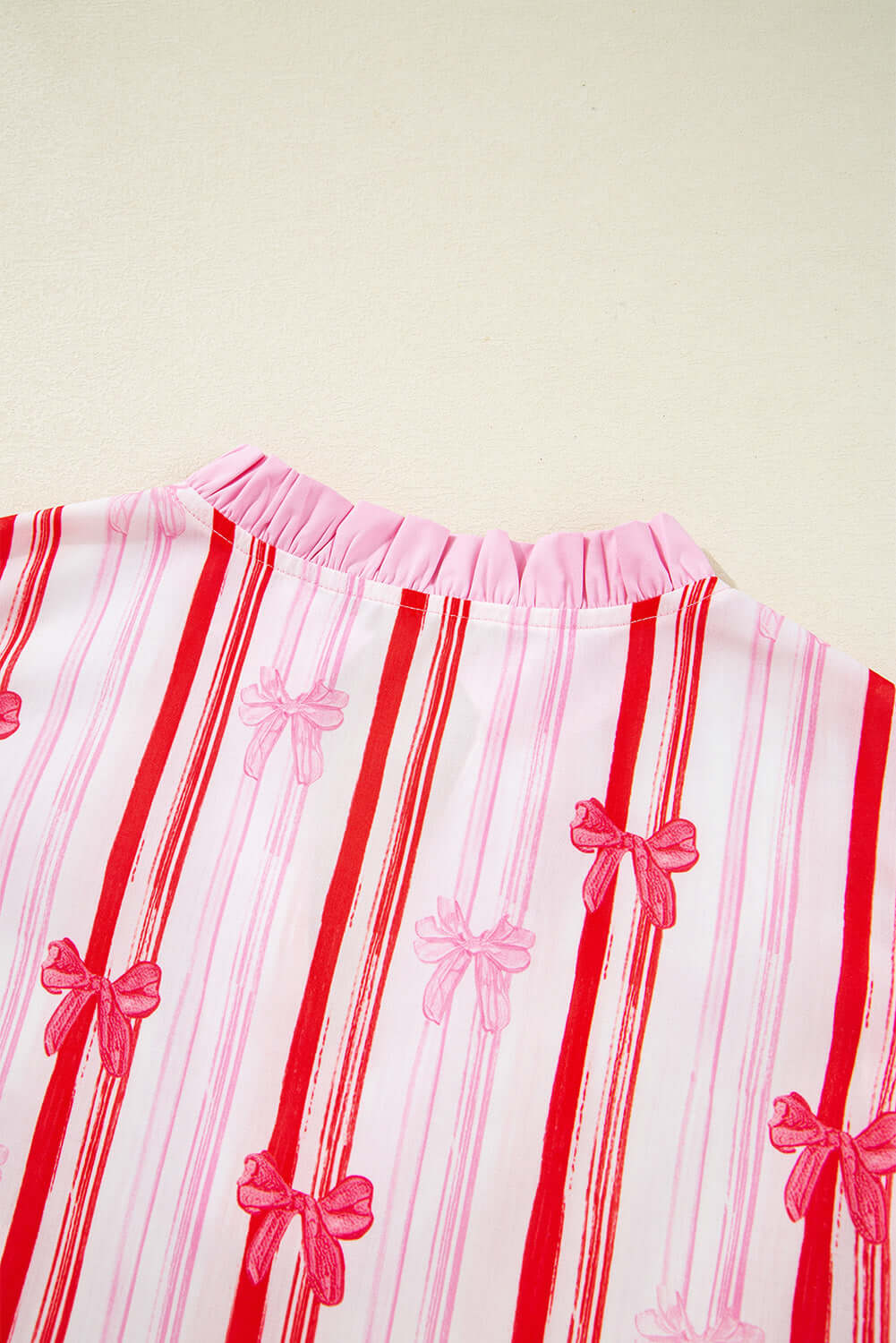Back detail of the Ribbon Reign Top featuring pink bow print on striped fabric.